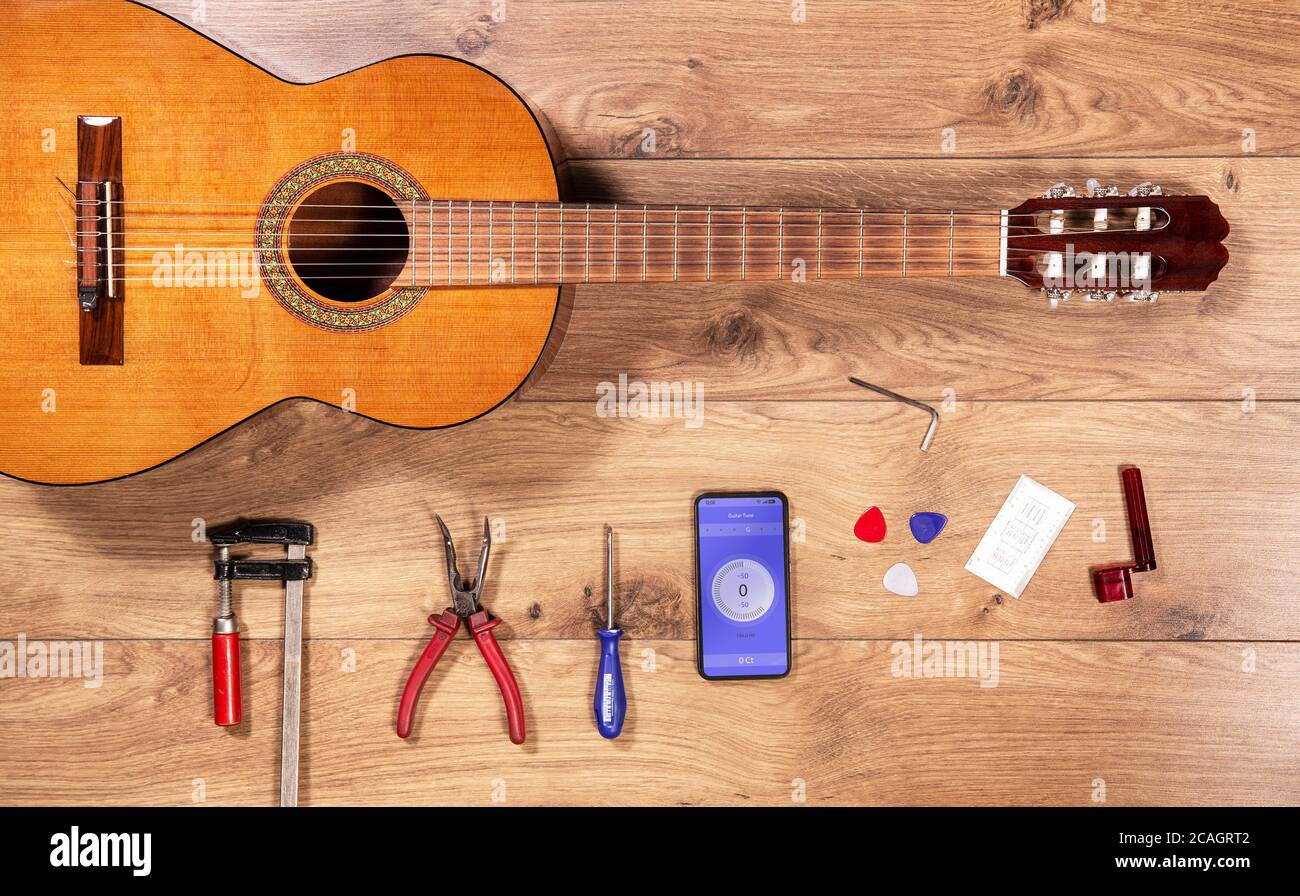 Vista dall'alto più lustra con chitarra classica e strumenti. Scrivania artigianale in legno con vista piatta e chitarra spagnola di flamenco. Foto Stock