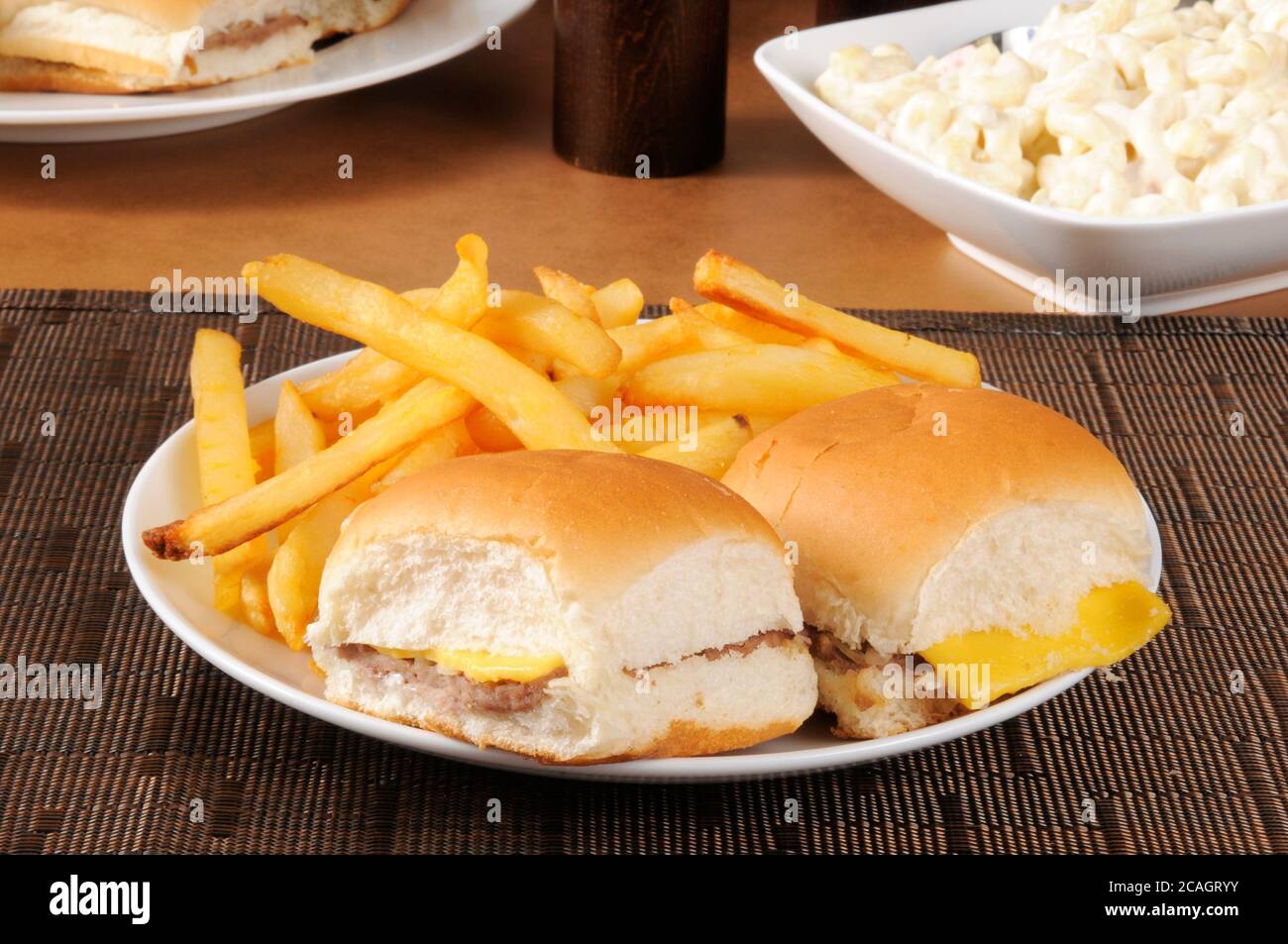 Un piatto di mini cheeseburgers e patatine fritte con insalata di macaroni Foto Stock