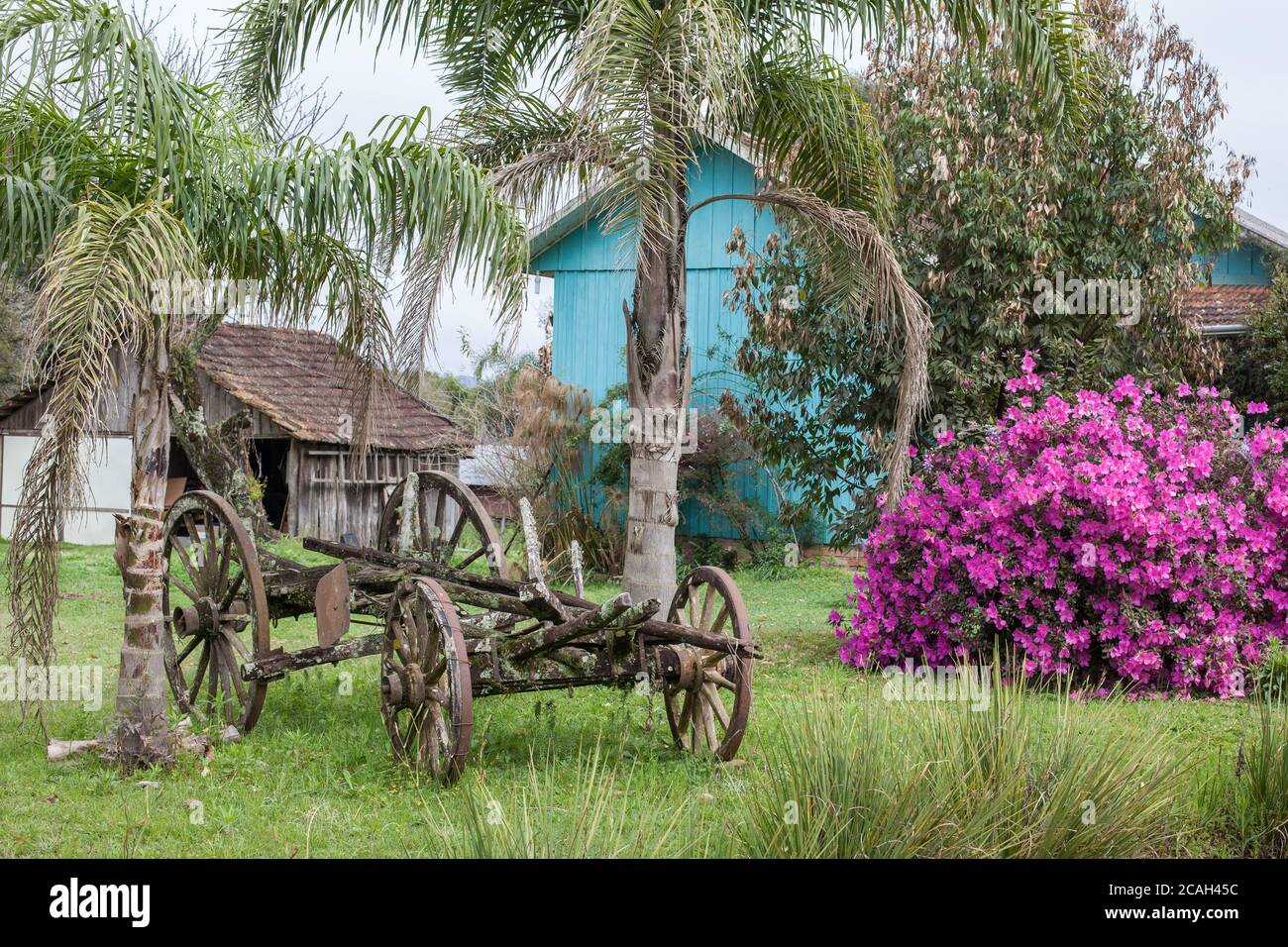 Un vecchio carro abbandonato con case in legno e fiori dentro lo sfondo Foto Stock