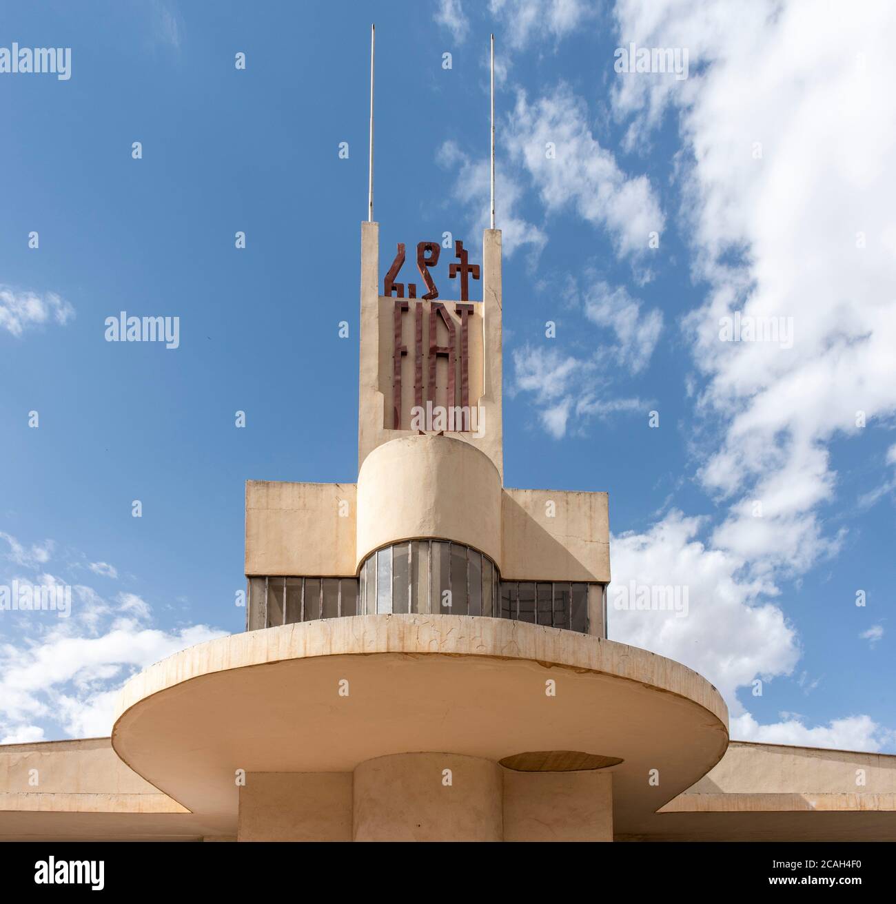 Vista assiale dal basso della sezione dell'ufficio e della facciata a prua a sbalzo, con segnaletica 'Fiat'. Stazione di servizio Fiat Tagliero, Asmara, Eritrea. Arcit Foto Stock