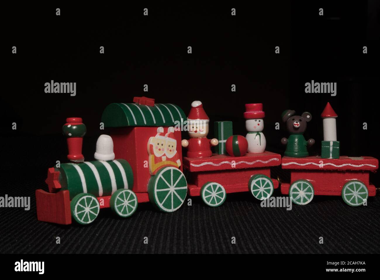 Bambini rossi`s treno di Natale su sfondo nero. Giocattolo di Capodanno. Foto Stock