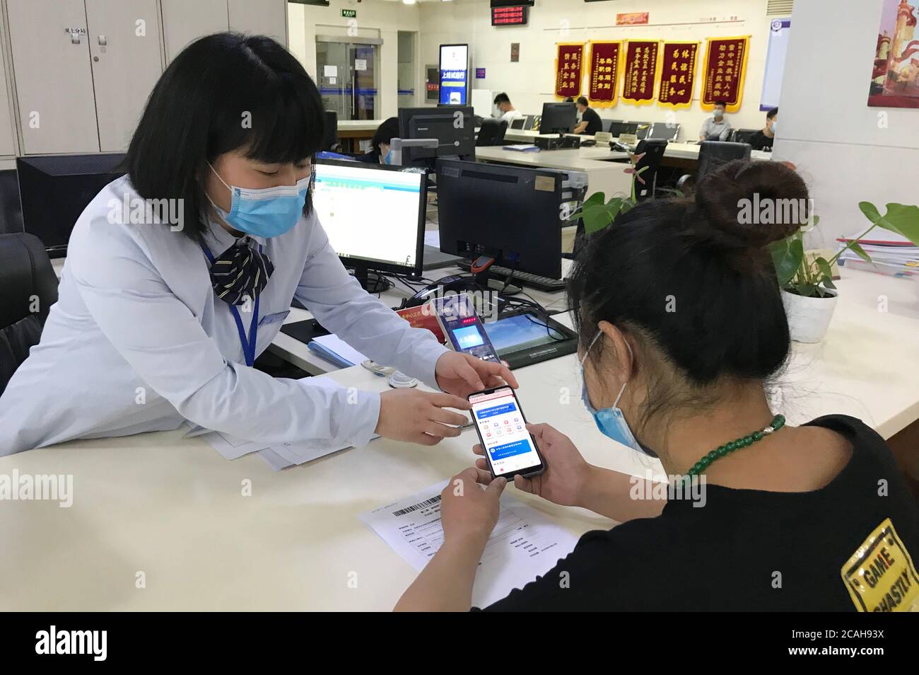 Pechino, Cina. 7 agosto 2020. Un membro del personale aiuta un cittadino a trattare con affari al centro di servizio di affari governativi del distretto di Daxing a Pechino, capitale della Cina, 22 maggio 2020. PER ANDARE CON XINHUA TITOLI DI AGOSTO. 7, 2020 Credit: Xinhua/Alamy Live News Foto Stock