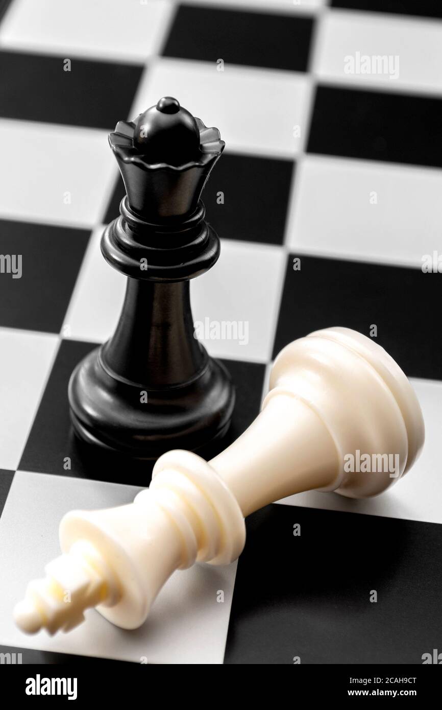 Checkmate, questioni di genere e caduta del concetto di leader potente con caduto re bianco e in piedi regina nera sulla scacchiera Foto Stock