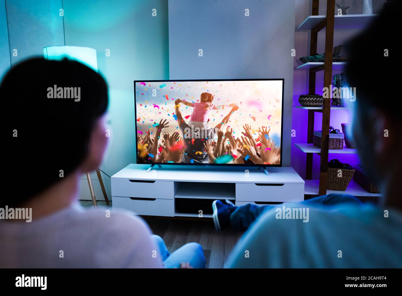 Coppia di famiglia che guarda la TV o il film sul divano Foto Stock