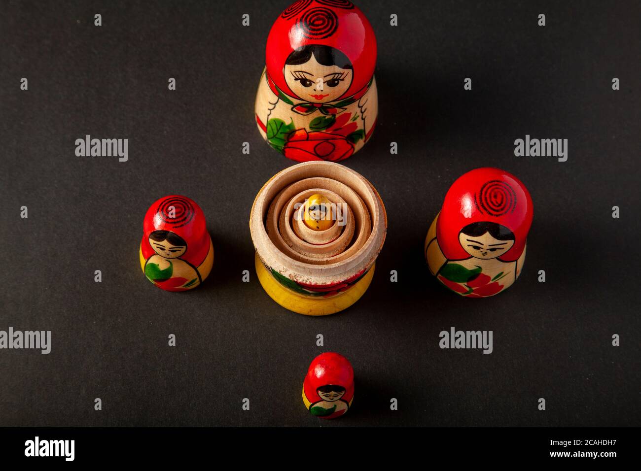 Le metà superiori delle bambole russe in legno sono collocate al buio background mentre i fave inferiori sono stati messi insieme in un concentrico moda con la bambola più piccola Foto Stock