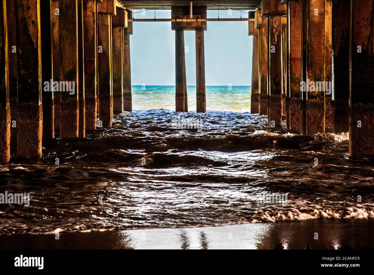 Le onde si infrangono contro le colonne del molo di legno sulla spiaggia di Atlantic City. New Jersey. Foto Stock