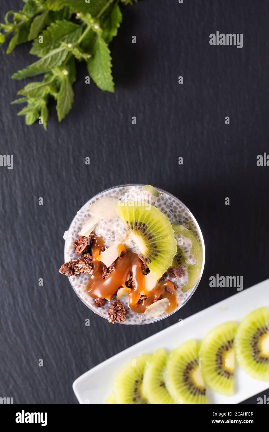 Concetto di cibo sano Bio Chia pudding con kiwi frutta e cioccolato muesli con spazio copia Foto Stock