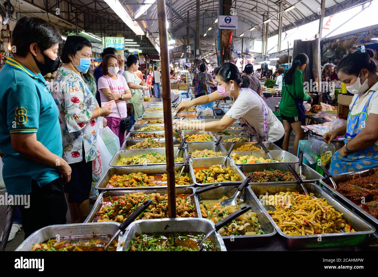 Folla di persone indossare maschera chirurgica viso, mentre l'acquisto di strada Cibo al mercato fresco di Samrong Foto Stock