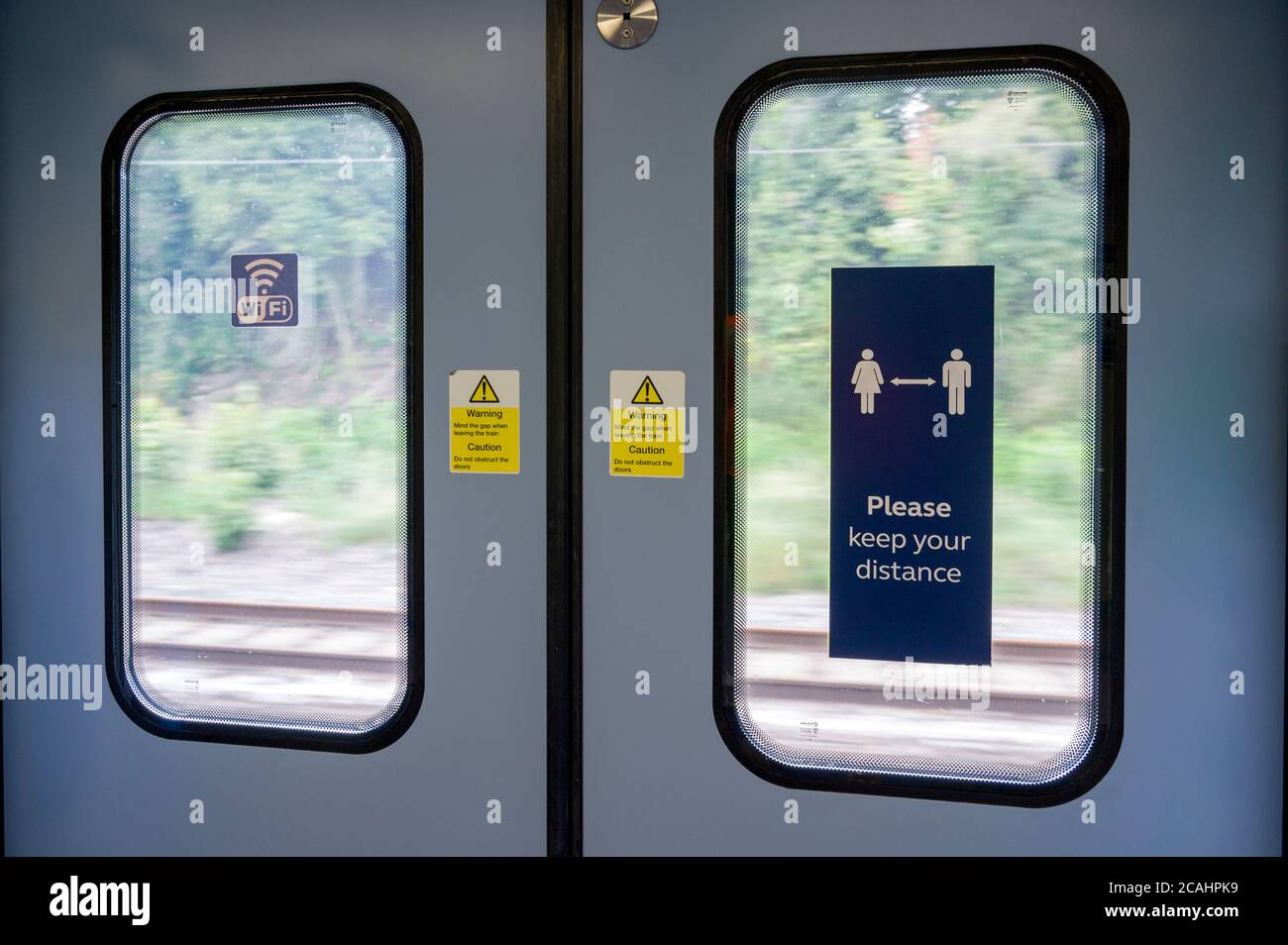 Segno di allontanamento sociale all'interno di una porta del treno passeggeri, durante la pandemia del Coronavirus Covid-19, Inghilterra, 2020. Foto Stock