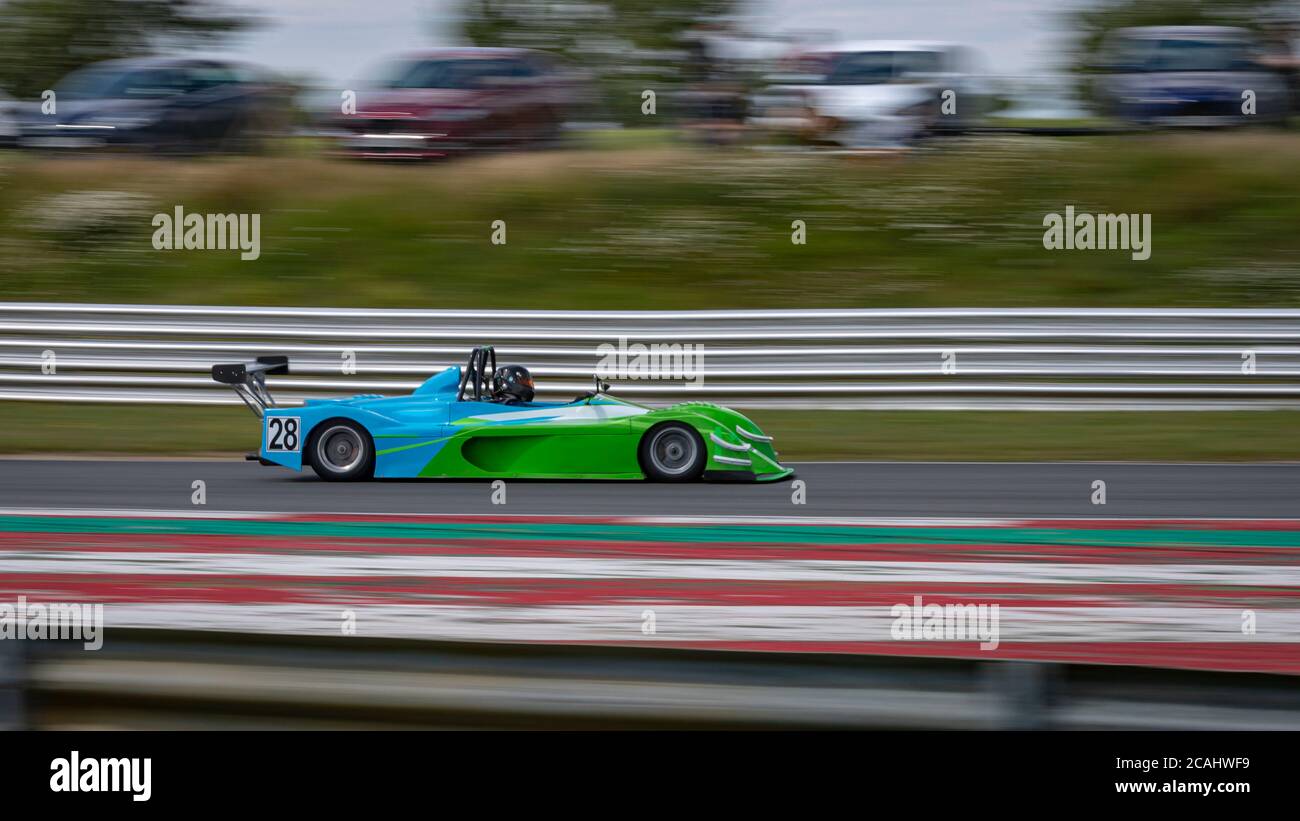 Una panoramica di una vettura da corsa blu e verde mentre si guida su una pista. Foto Stock