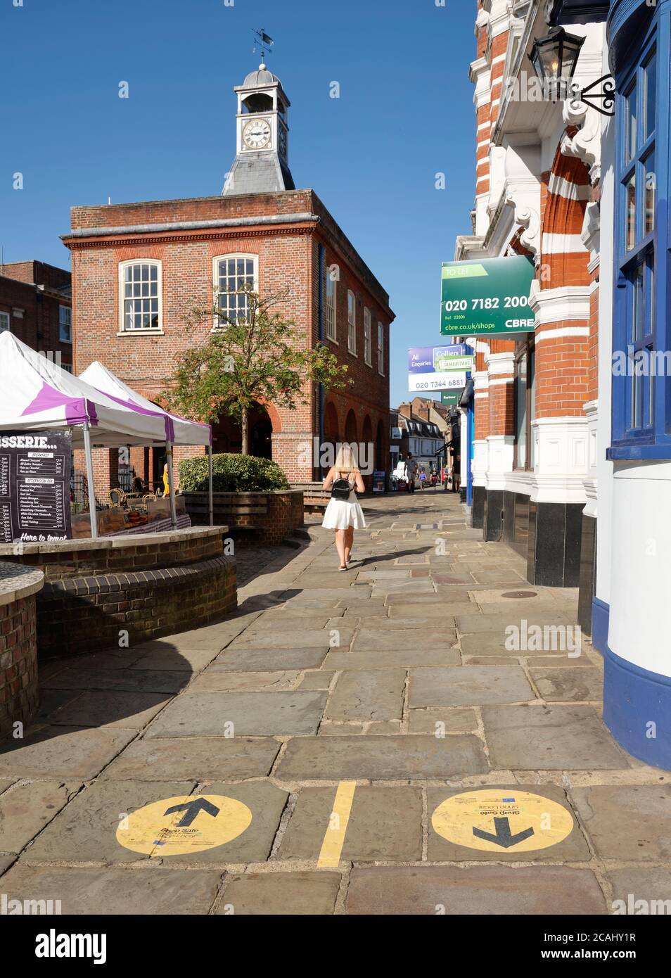 Reigate Surrey High Street - Coronavirus pedone distanza sicura e direzione a senso unico marciapiede marcature mantenere le persone al sicuro. Negozio sicuro locale Foto Stock