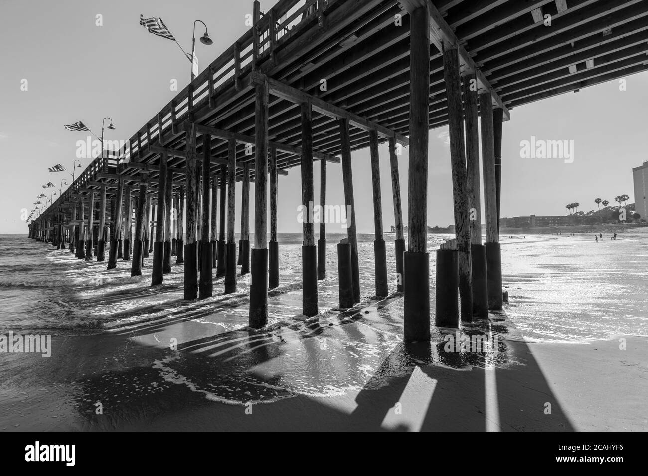 Vista in bianco e nero sotto lo storico molo in legno sulla spiaggia di Ventura, nella California meridionale. Foto Stock