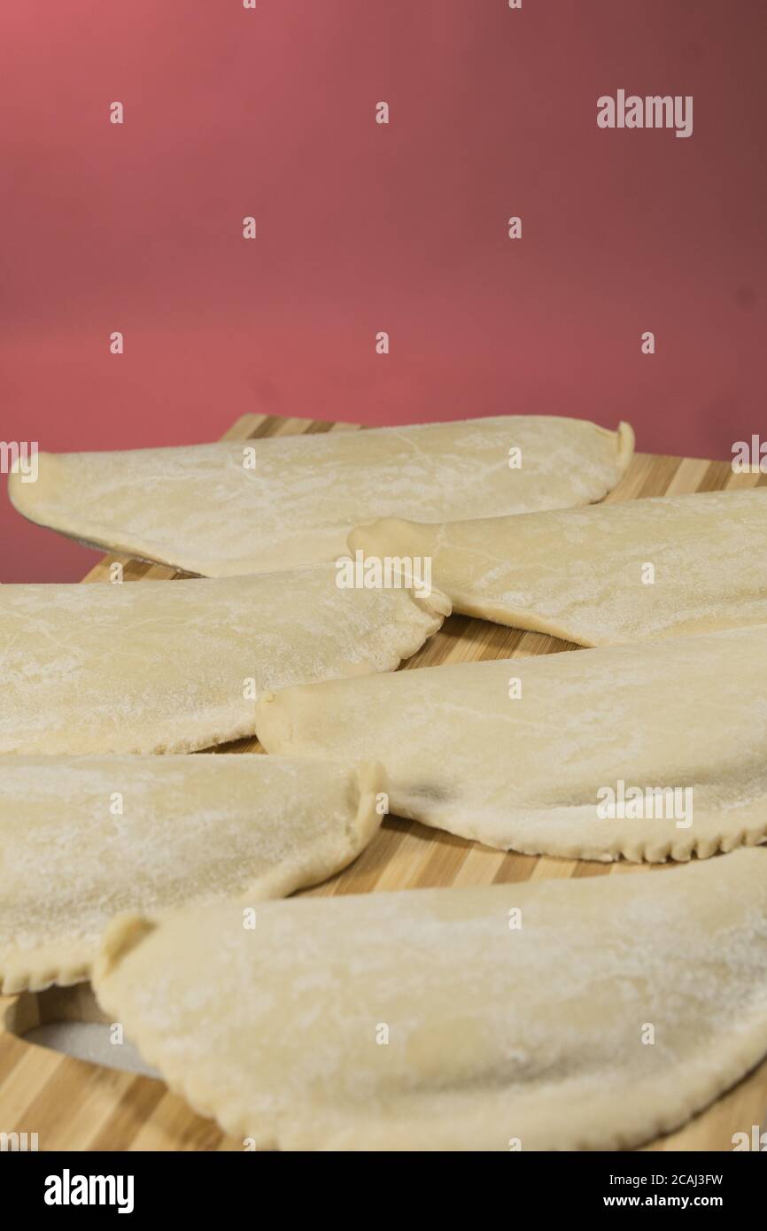 Cheburks freddo con ripieno, su lavagna di legno. Foto Stock
