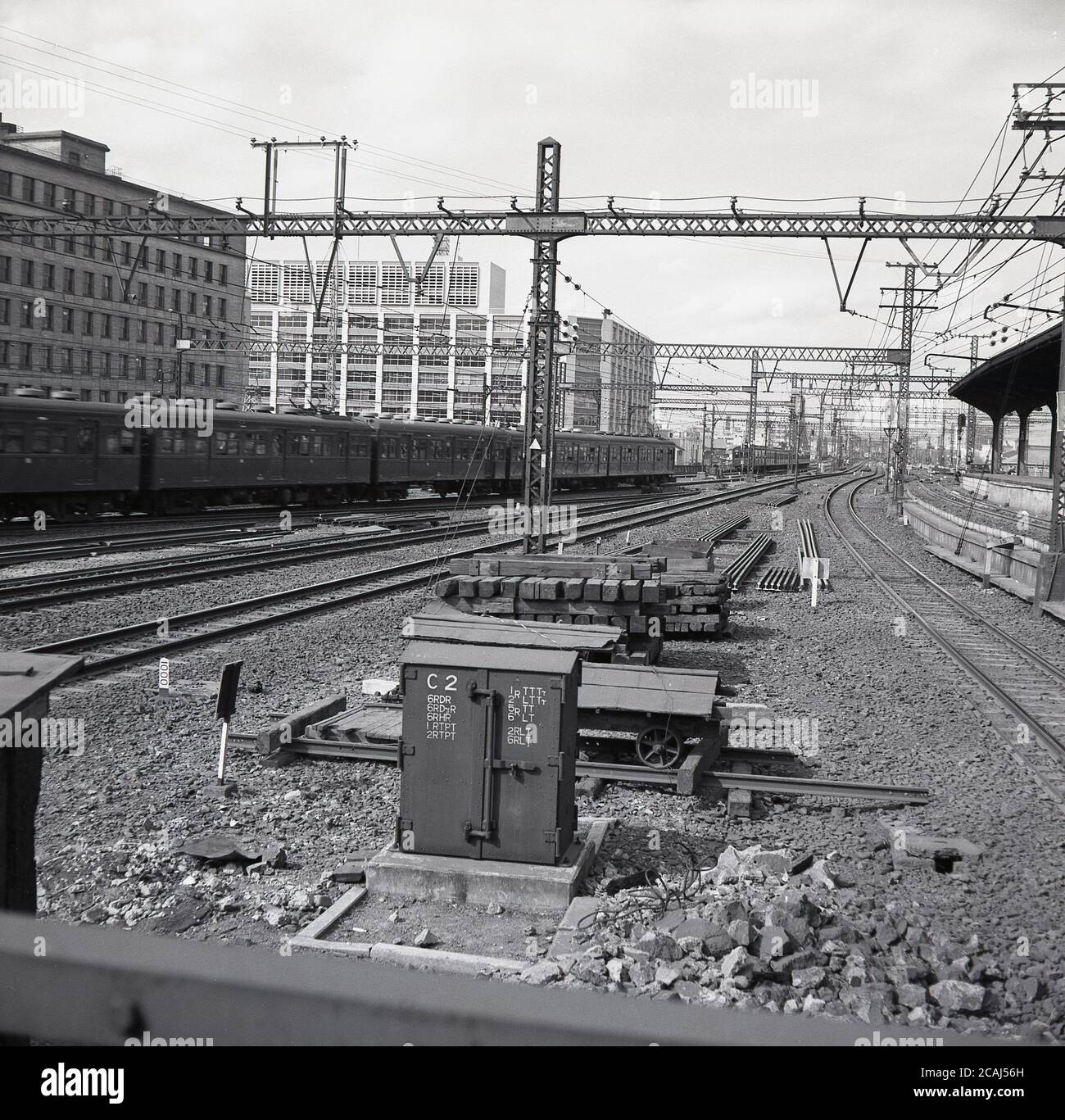 Anni '60, storica, Tokyo, Giappone, numerose linee ferroviarie e treni su binari ferroviari, con cavi elettrici in alto a un bivio fuori città. Foto Stock