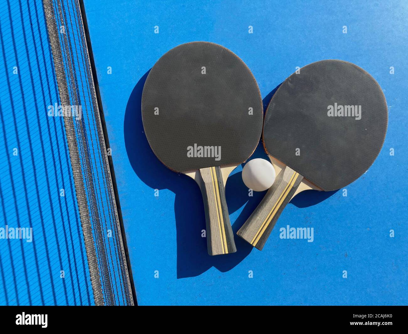 Set di due pipistrelli da ping pong e una palla un tavolo da ping-pong con rete Foto Stock