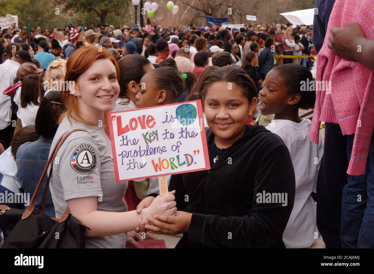 Le ragazze anglo e afroamericane tengono il segno che promuove l'amore e la tolleranza a Martin Luther King Jr. Giorno festeggiamenti, Austin, TX. ©Janis Daemmrich Foto Stock