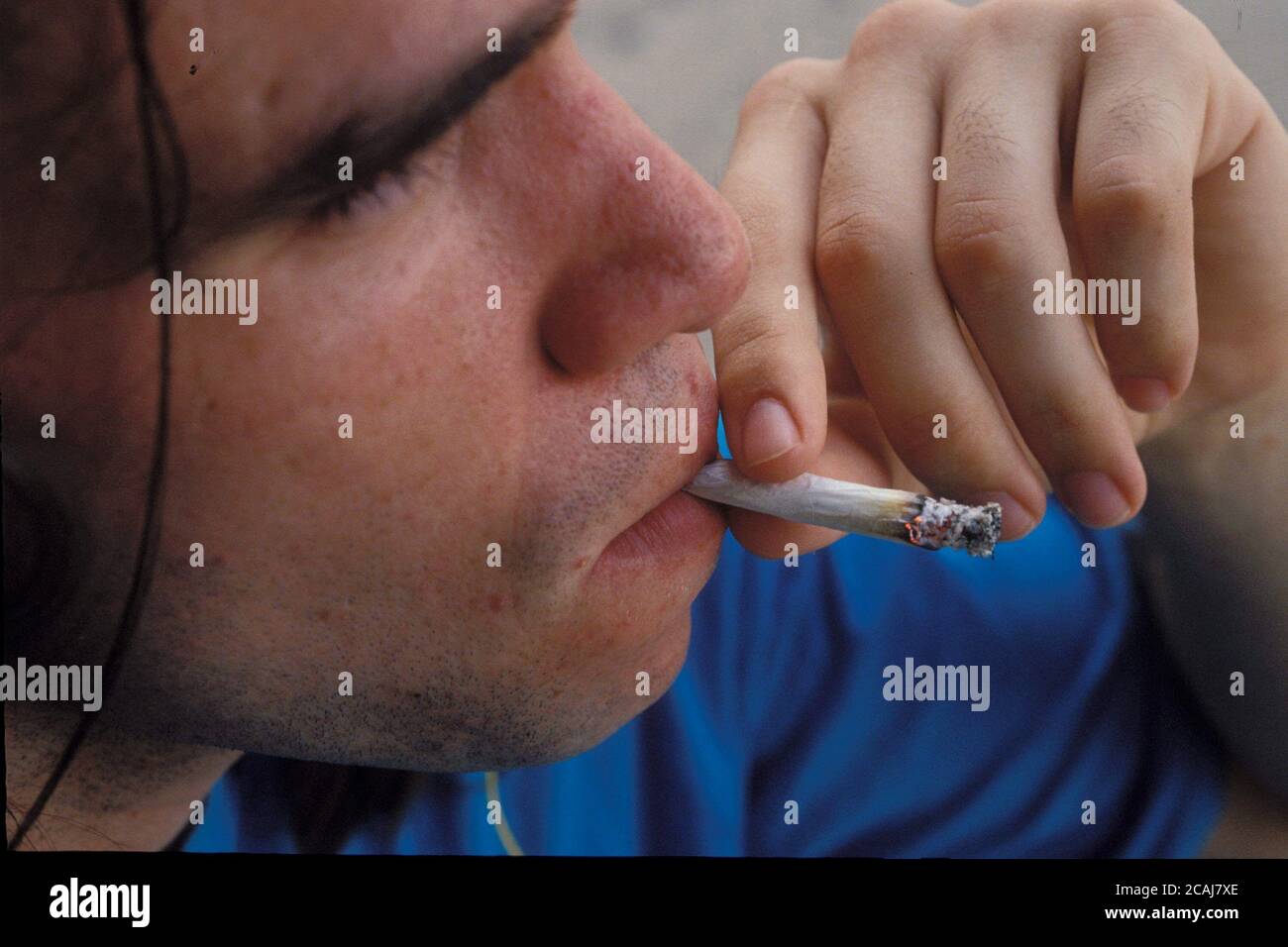 Primo piano di un giovane adolescente anglo che fuma una sigaretta di marijuana a scuola ad Austin, Texas. Versione del modello. ©Bob Daemmrich Foto Stock