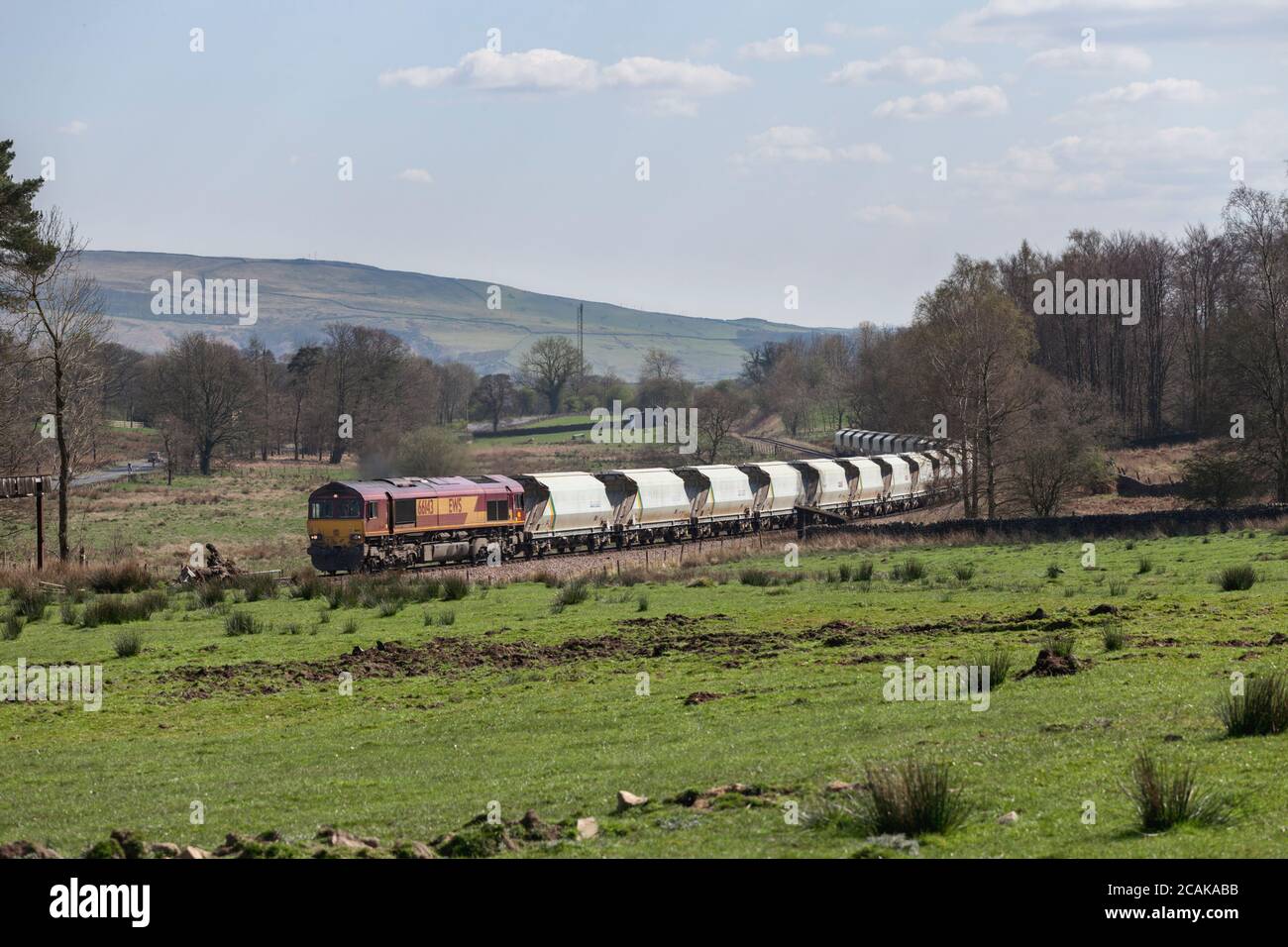 Una classe di carico DB 66 locomotive66143 che trasporta un treno di tramogge di aggregati vuoti sulla linea di diramazione di trasporto di Rylstone vicino a Skipton, Yorkshire Foto Stock