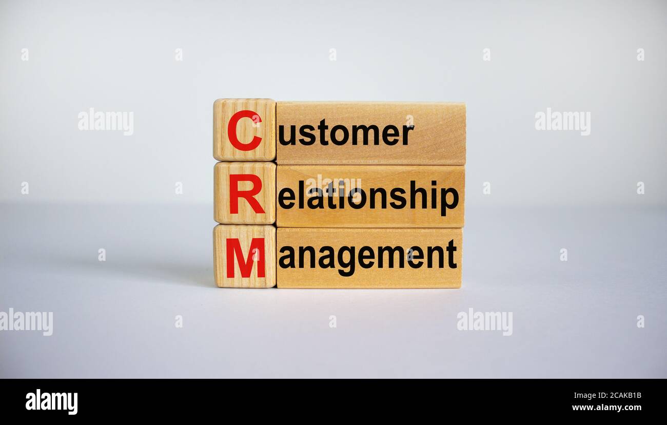 Parole concettuali "CRM, gestione delle relazioni con i clienti" su cubi e blocchi su uno sfondo bianco bellissimo. Concetto aziendale. Spazio di copia. Foto Stock
