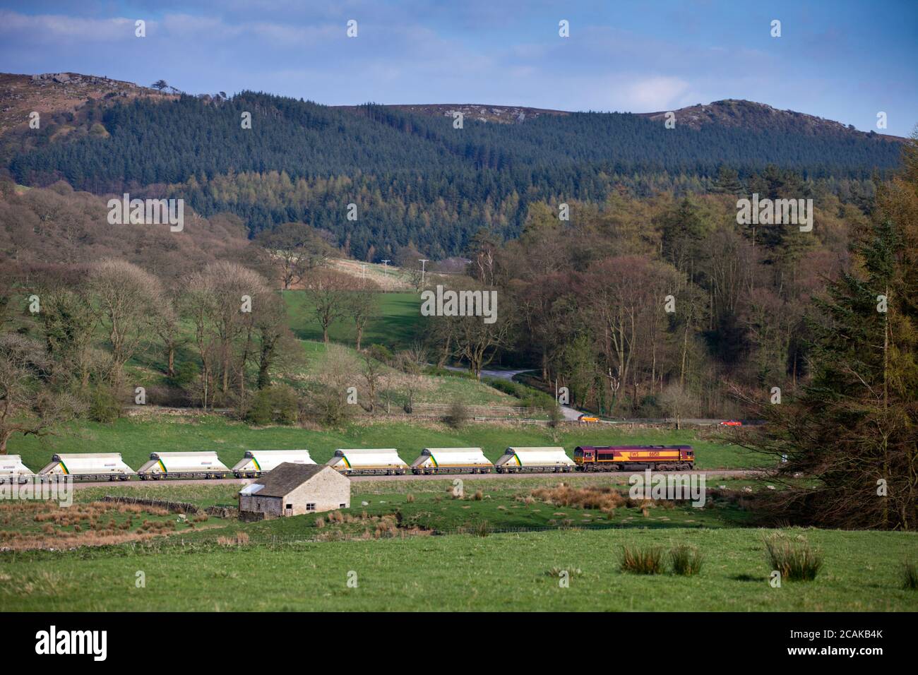 Un DB Cargo classe 66 locomotore trasporta un treno di aggregati da Grassington sul trasporto merci Rylstone derivazione di linea nelle vicinanze Skipton, Yorkshire Foto Stock