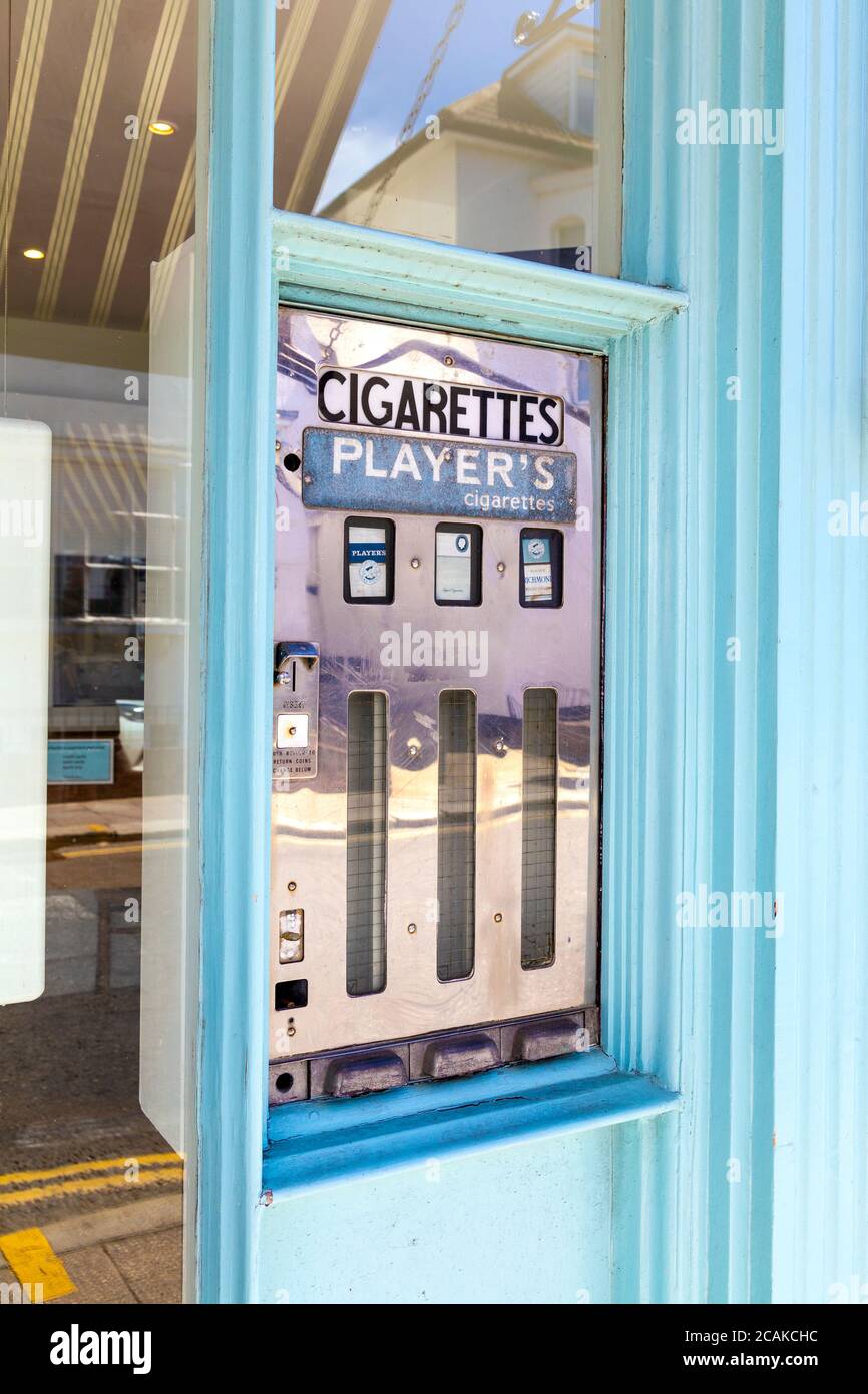 Distributore automatico di sigarette d'epoca su High Street, Whitstable, Kent, Regno Unito Foto Stock