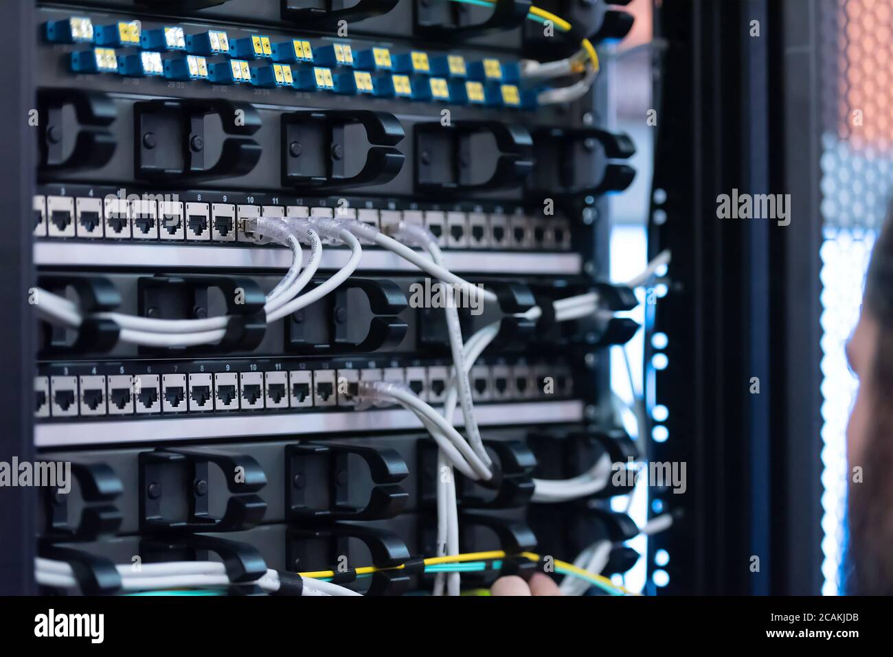 Un esperto Engeneer nella sala server del data center che collega i cavi nell'armadio server nella sala server di rete. Foto Stock