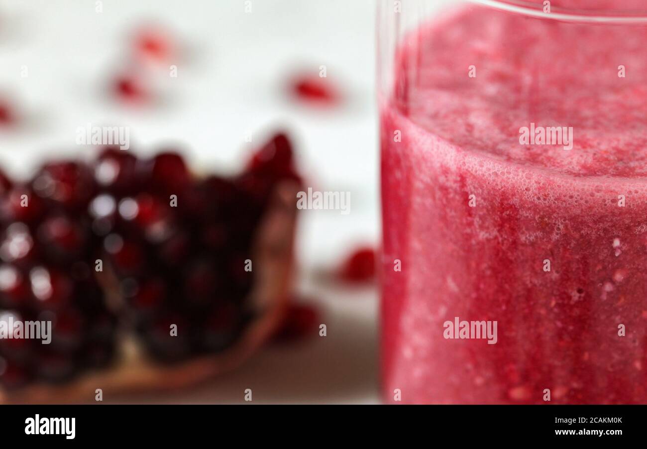 Dettaglio delle bolle in frullato rosa, melograno sfocato sullo sfondo Foto Stock