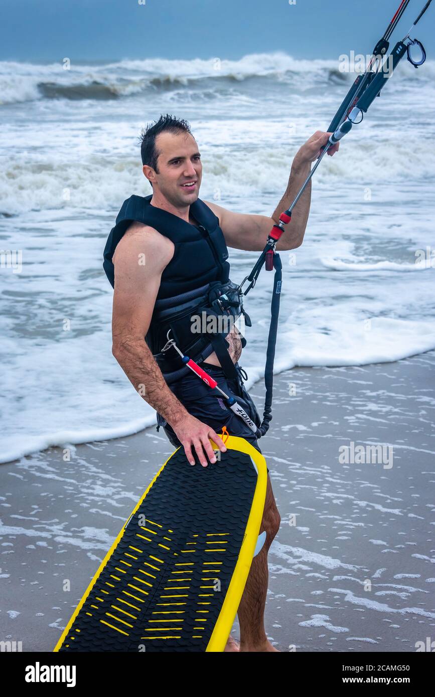 Il kiteboarder Calvin Curry si trova tra un giro e l'altro durante una sessione di gitesurf con pattuglia all'alba, mentre le isole della tempesta tropicale passavano da Jacksonville Beach, Florida. (STATI UNITI) Foto Stock