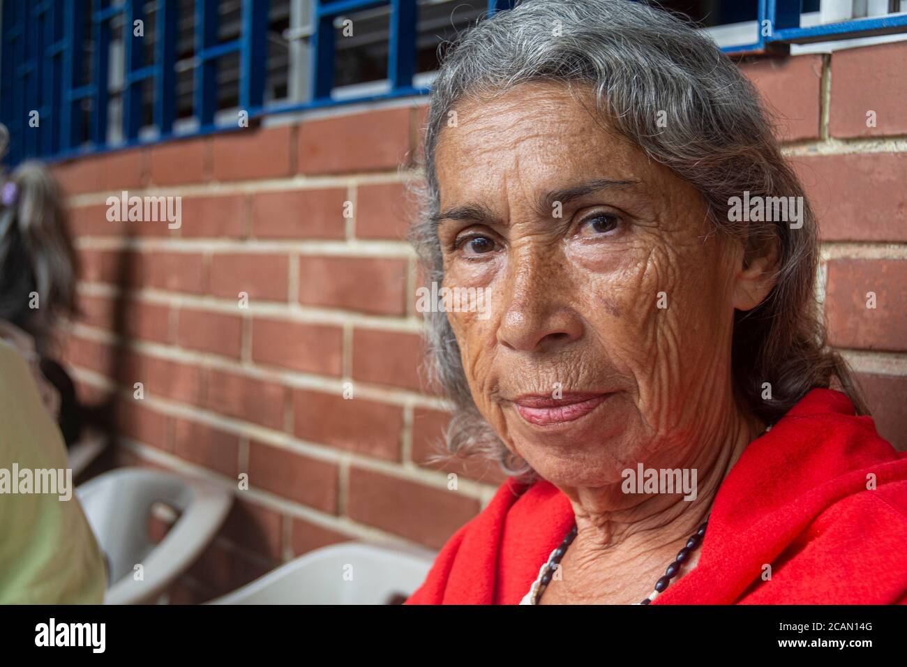 Una donna anziana, chiamata gruppo della nonna, attende la vostra chiamata per il pranzo. Nella parrocchia Maria Auxiliadora di Boleita, Caracas, Venezuela, attraverso il Foto Stock