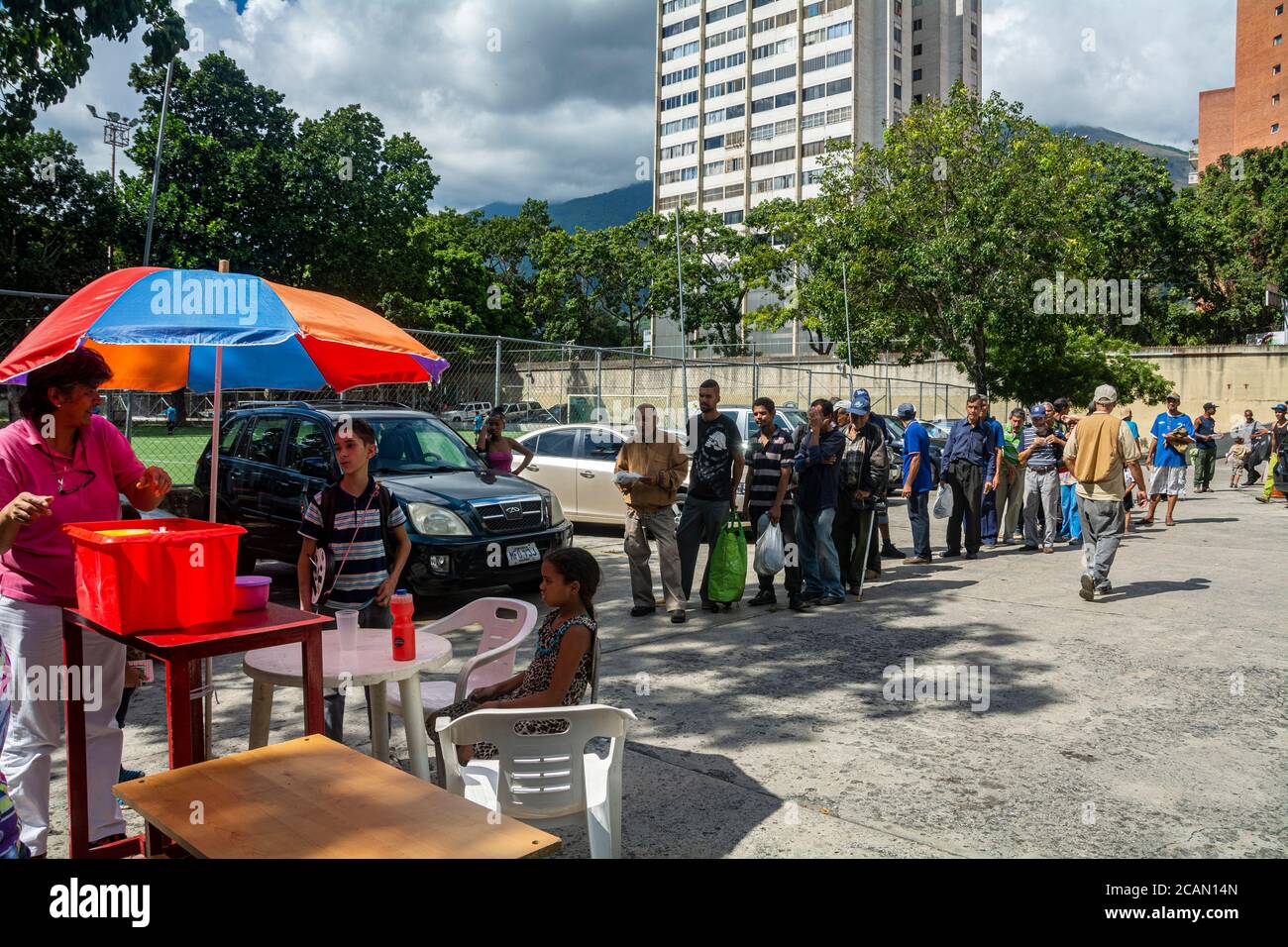 Da molto presto in poi, le persone si allineano per poter entrare nel luogo in modo ordinato. Nella parrocchia Maria Auxiliadora di Boleita, Caracas, Venezuela, Foto Stock