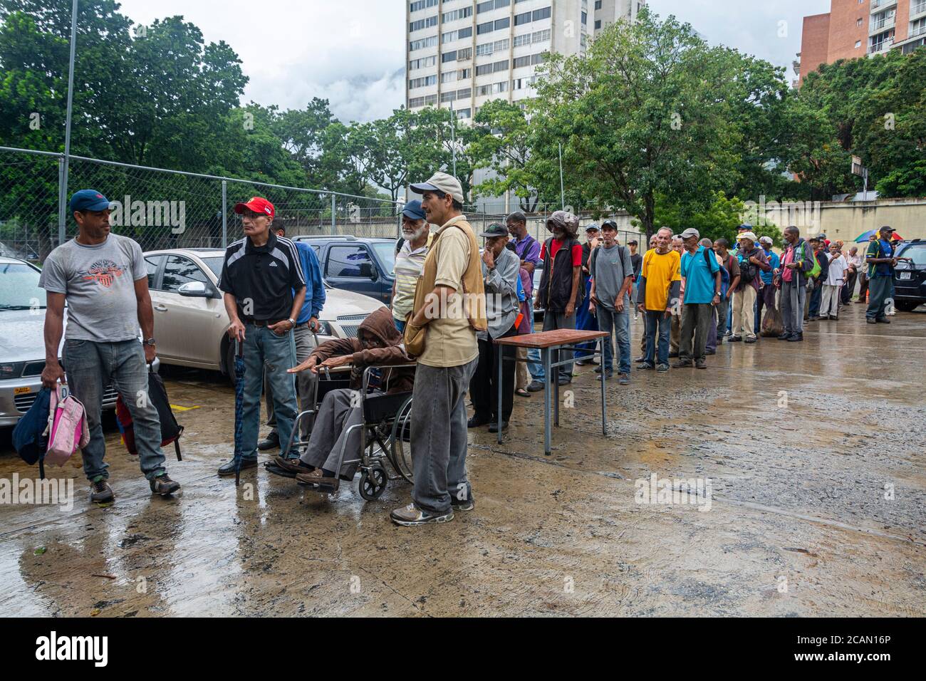 Da molto presto in poi, le persone si allineano per poter entrare nel luogo in modo ordinato. Nella parrocchia Maria Auxiliadora di Boleita, Caracas, Venezuela, Foto Stock