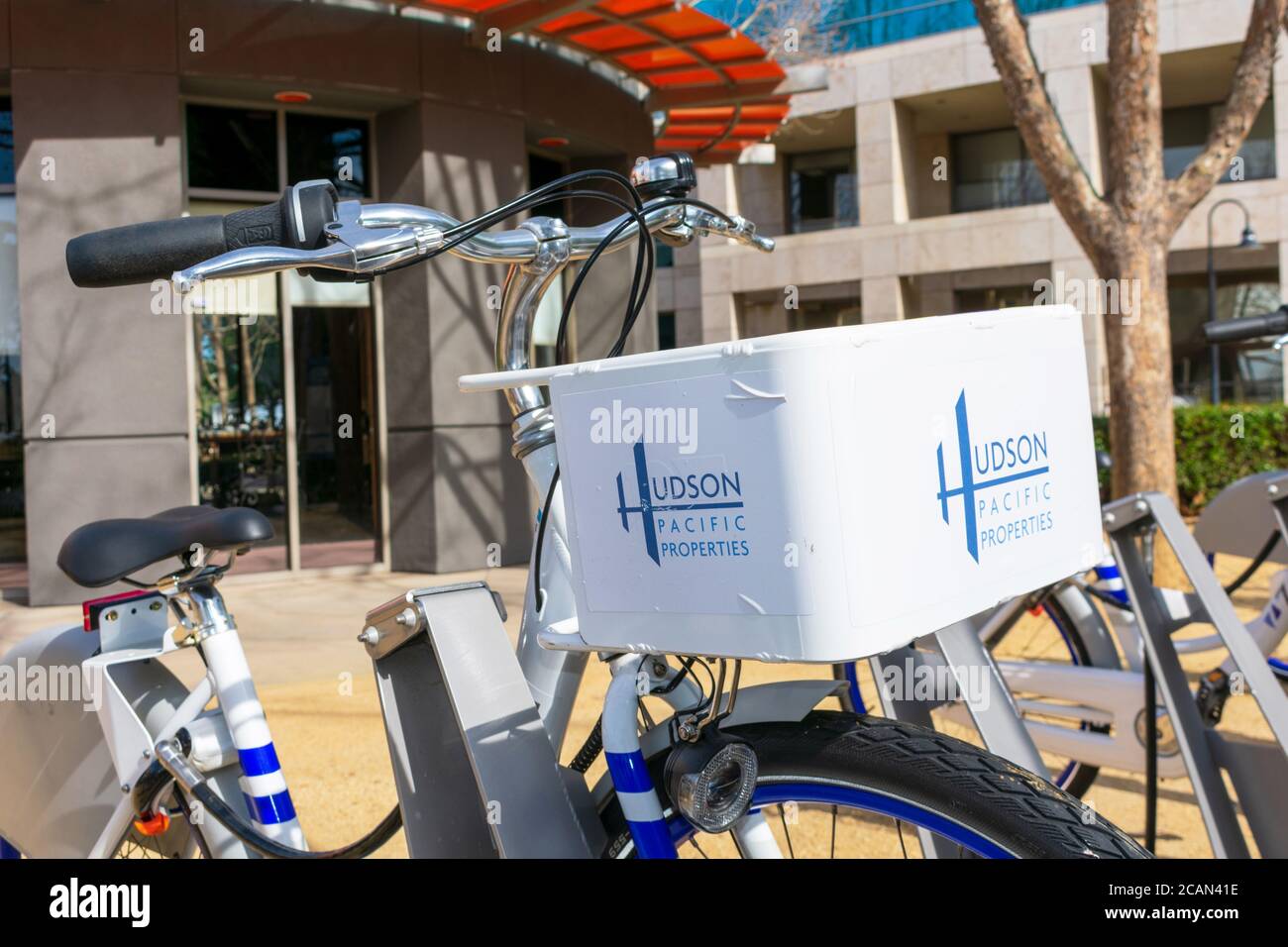 Le proprietà di Hudson Pacific firmano sulla bici a pedale condivisa con lo sfondo commerciale dello spazio dell'ufficio - San Jose, California, USA - 2020 Foto Stock