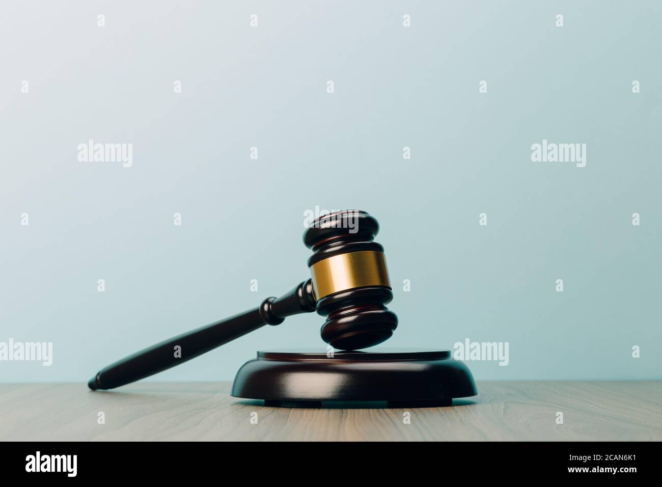 Simbolo di legge e giustizia su un tavolo di legno e sfondo blu nell'ufficio legale Foto Stock