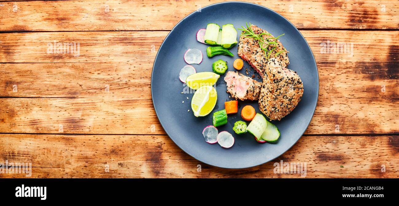 Bistecca di tonno al forno con guarnitura di verdure. Pesce cotto con verdure. Foto Stock