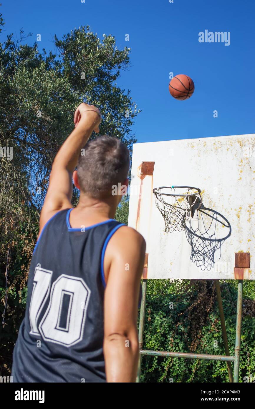 lefty giocatore di pallacanestro tiro in un parco giochi all'aperto Foto Stock