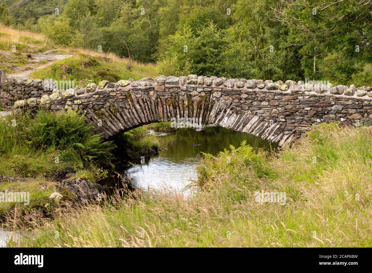 Ponte di pietra a Watendlath Tarn nel Lake District, Inghilterra Foto Stock