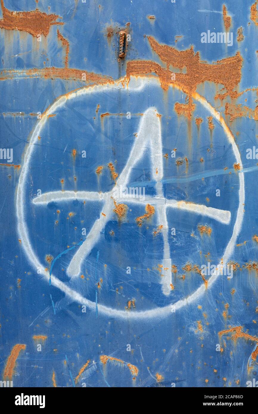 Simbolo dell'anarchismo su una superficie blu e arrugginita Foto Stock