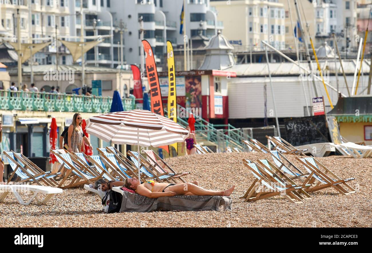 Brighton UK 8 agosto 2020 - bagnanti sulla spiaggia di Brighton come la temperatura è prevista per raggiungere oltre 30 gradi in alcune parti del Sud-est: Credit Simon Dack / Alamy Live News Foto Stock