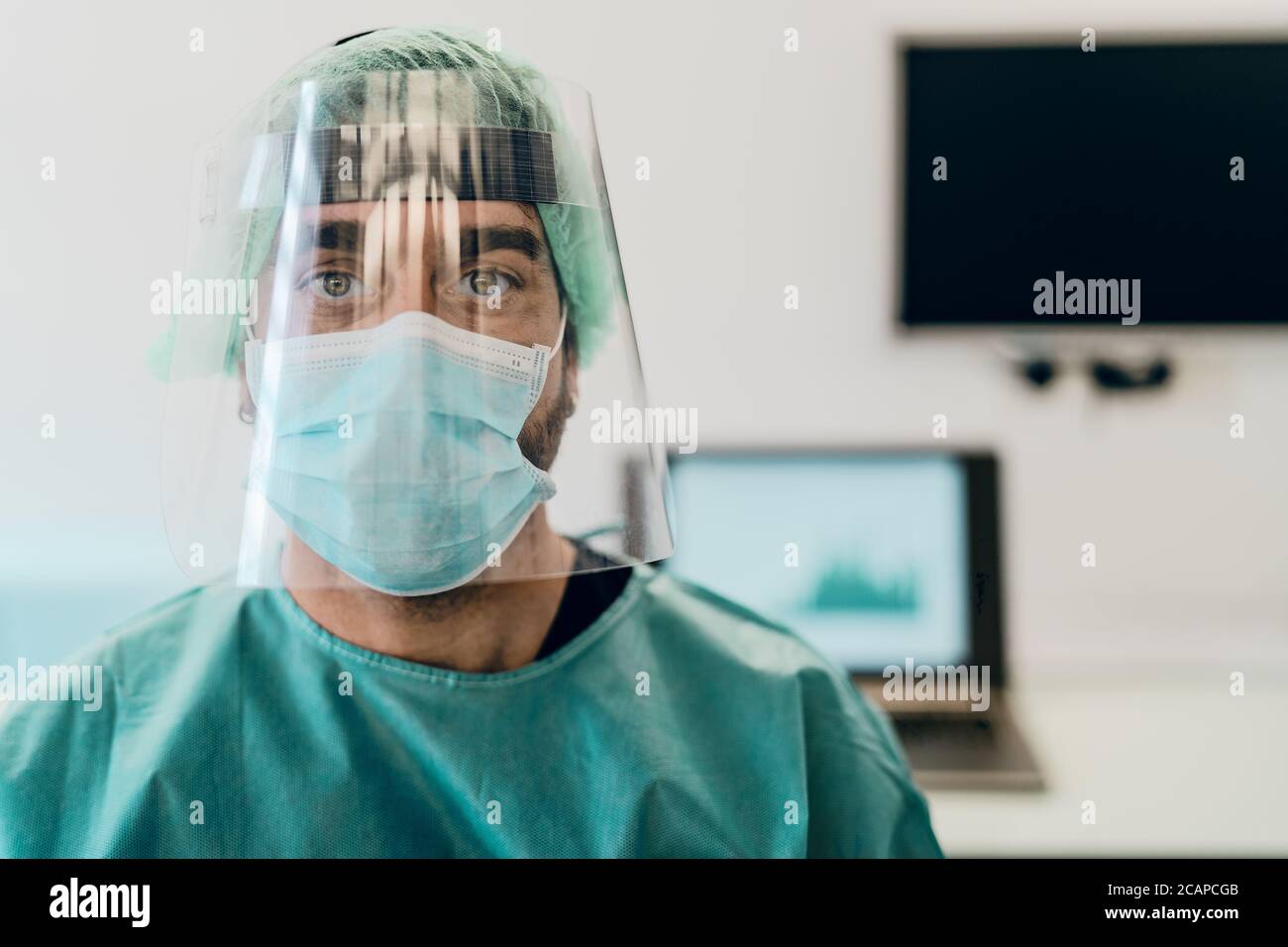 Medico che indossa la maschera chirurgica del viso ppe e visiera che combatte contro l'epidemia di virus corona Foto Stock