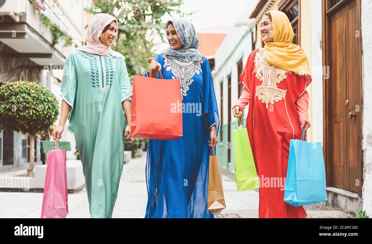 Felici le donne musulmane facendo shopping nel centro città - Arabian teen ragazze divertirsi acquistando nuove tradizionali abiti arabi in mall Foto Stock