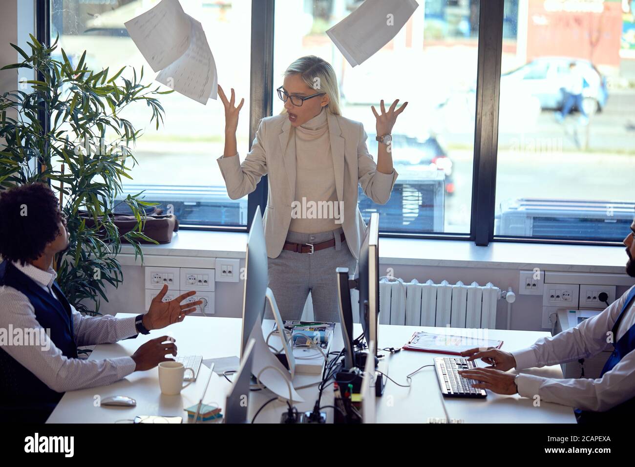 La manager femminile non è soddisfatta dei risultati del progetto che gridano ai dipendenti Foto Stock