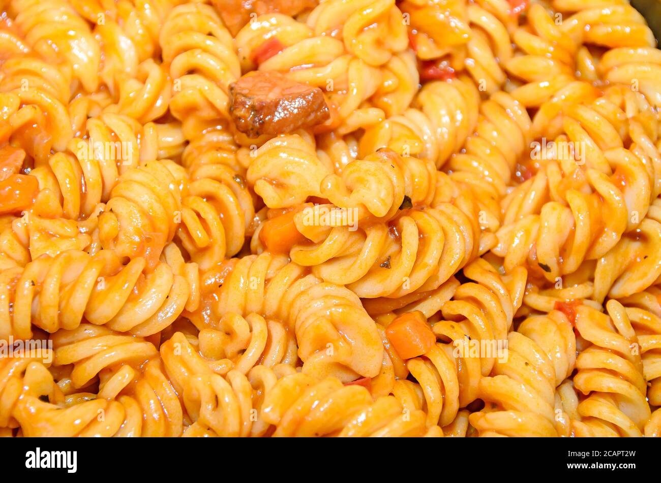 Spaghetti di pasta con salsa di pomodoro rosso, arrabiata con funghi, pancetta, parmezan. Foto Stock