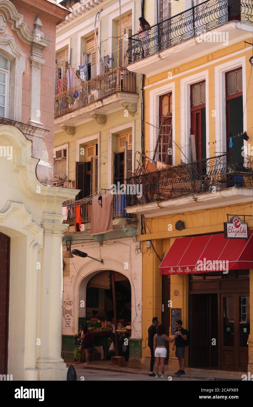 Scena di strada a l'Avana, Cuba con negozi al piano terra, e appartamenti con balconi sopra con linee di lavaggio Foto Stock