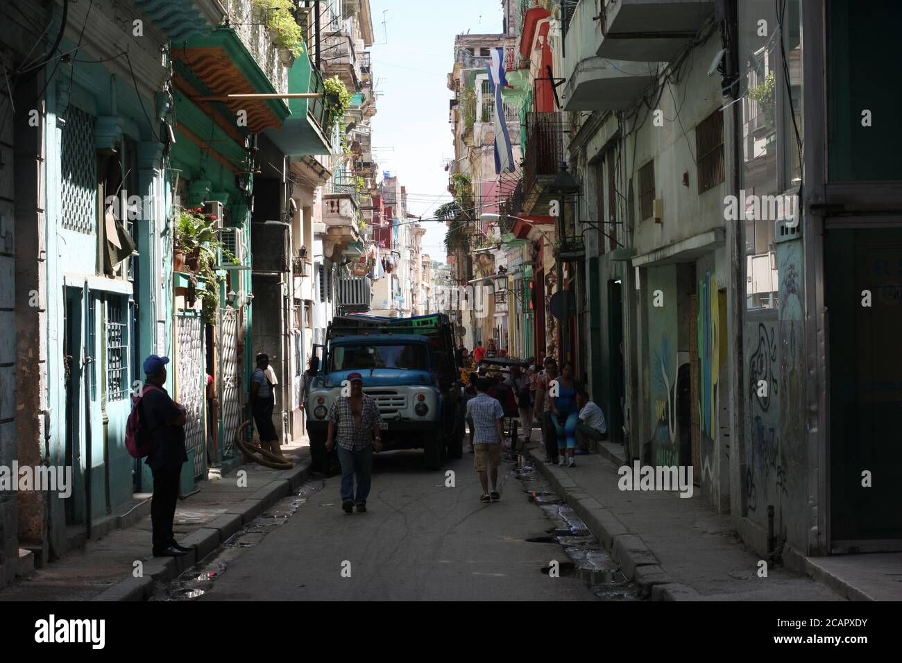 Affollata scena di strada con camion che schiacciano i venditori passati in strada stretta, l'Avana, Cuba Foto Stock