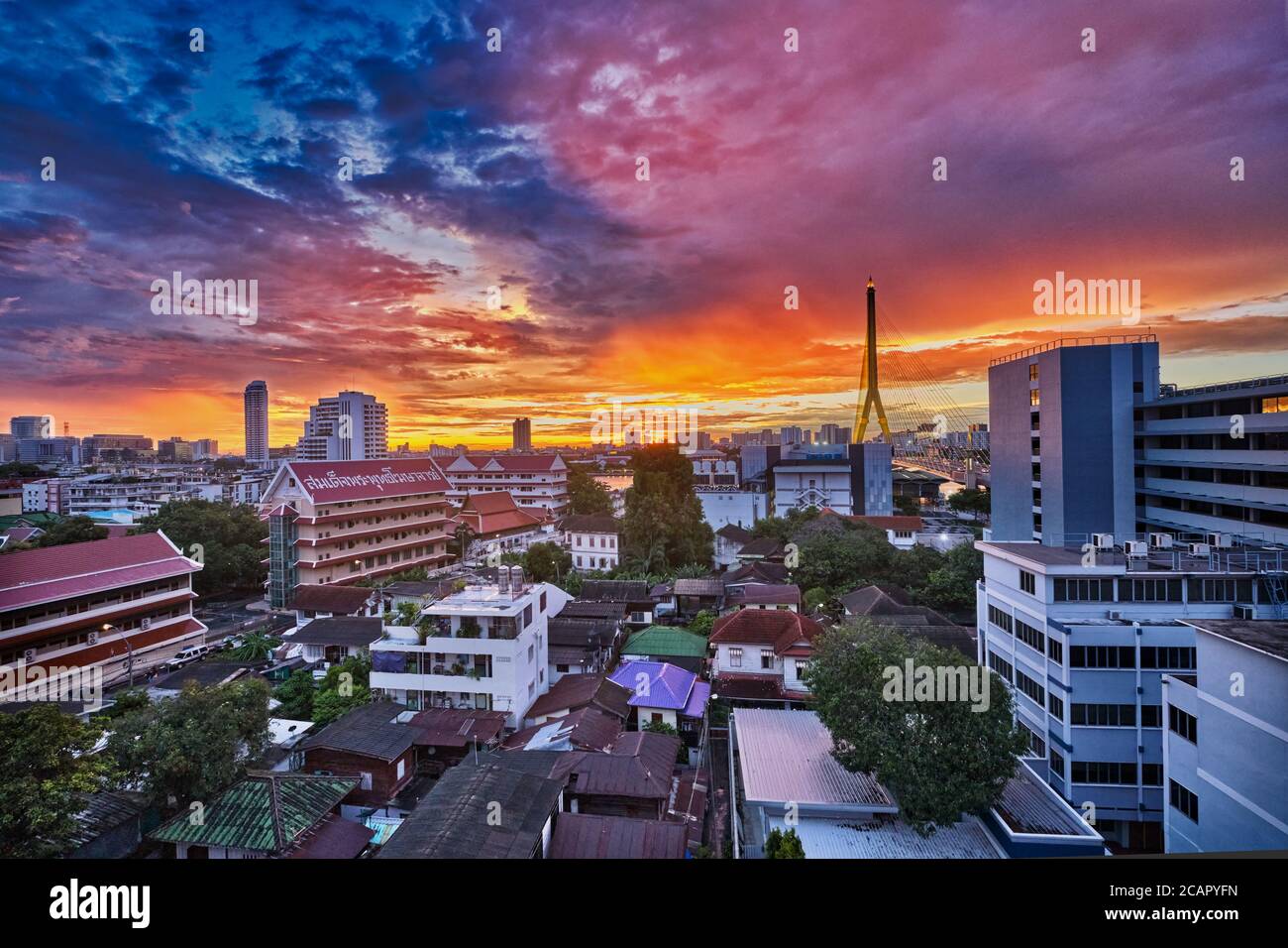 Un tramonto multicolore su Phra Nakhon (Pranakorn), il centro storico di Bangkok, Thailandia; a sinistra: (tempio) Wat Sam Phraya, a destra: Rama VIII Ponte Foto Stock