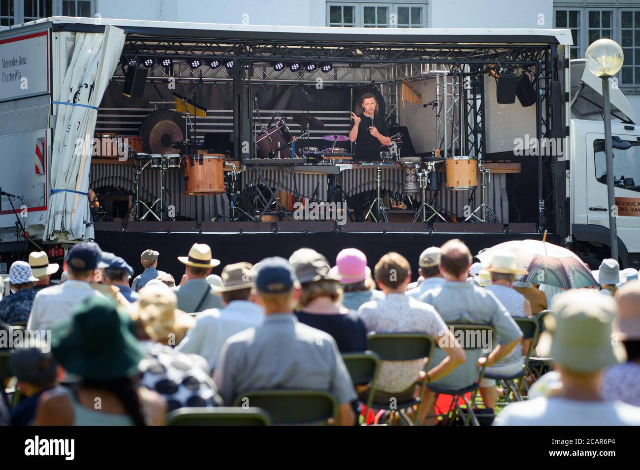 Schleswig, Germania. 8 agosto 2020. Martin Grubinger, musicista e percussionista, parla al suo pubblico all'inizio del Festival del Musik Schleswig-Holstein, di fronte al Castello di Gottorf, dal retro di un camion. Credit: Gregor Fischer/dpa/Alamy Live News Foto Stock