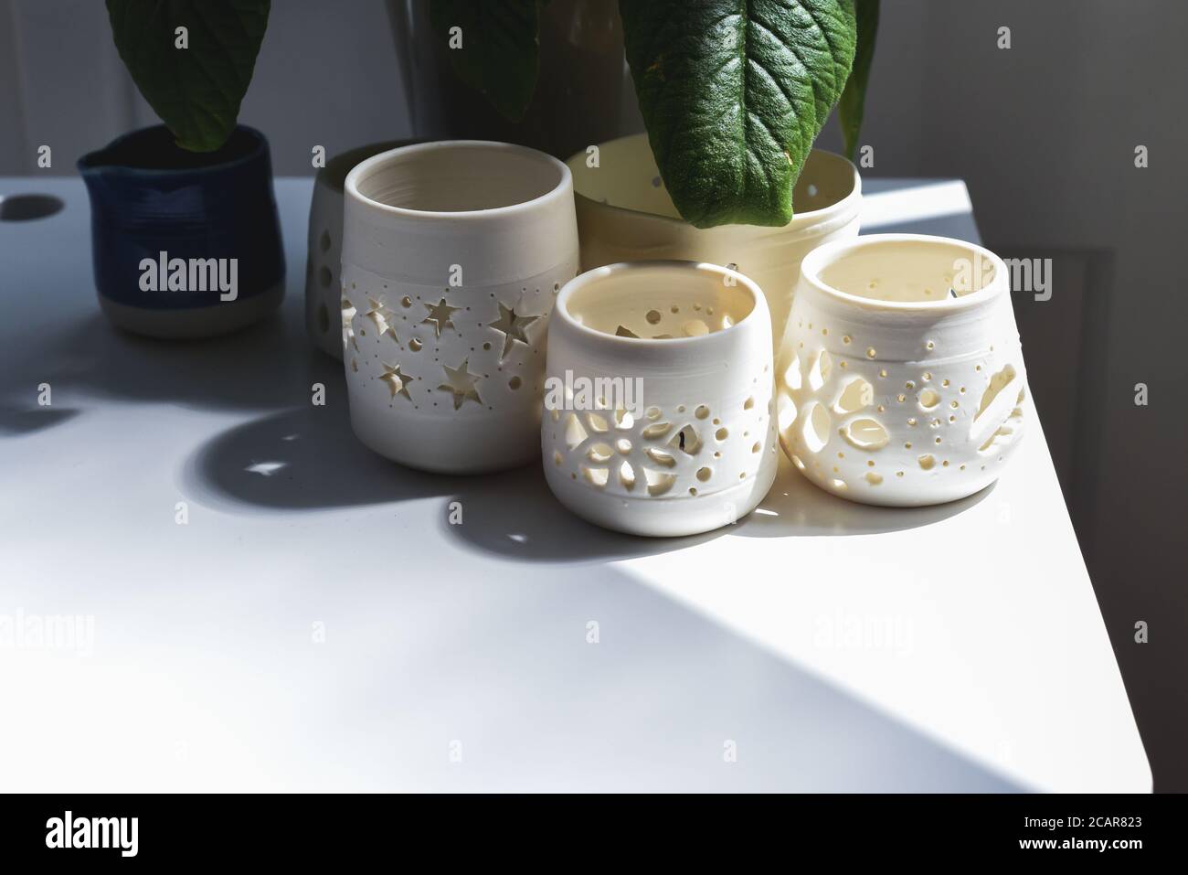 Gruppo di vasi in ceramica fatti a mano e ciotole decorative in ceramica all'interno della stanza Foto Stock