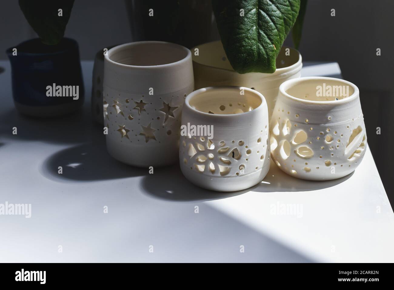 Gruppo di vasi in ceramica fatti a mano e ciotole decorative in ceramica all'interno della stanza Foto Stock