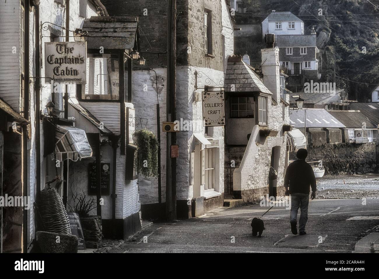 Un uomo che cammina il suo cane. Polperro villaggio di pescatori. Cornovaglia. Inghilterra. REGNO UNITO Foto Stock