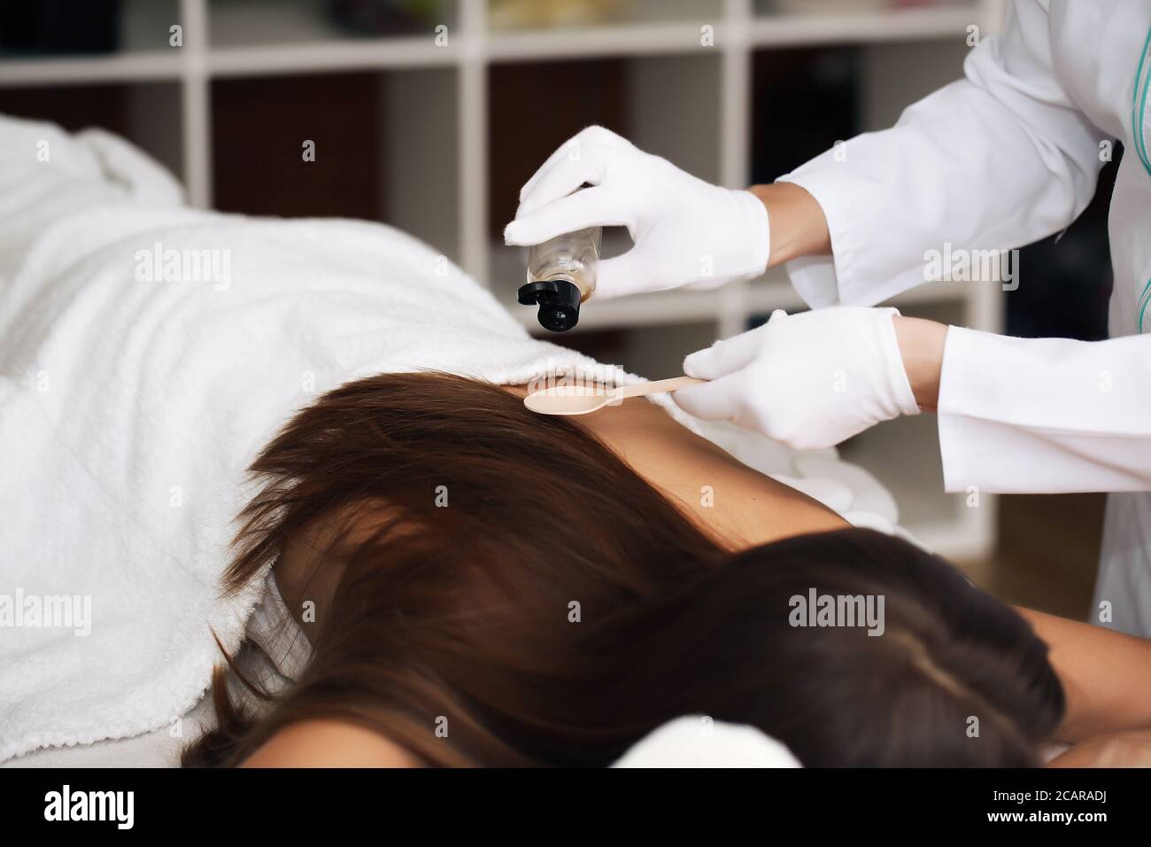 Bellezza e spa concept - donna felice in spa salone giacente sulla scrivania di massaggio Foto Stock
